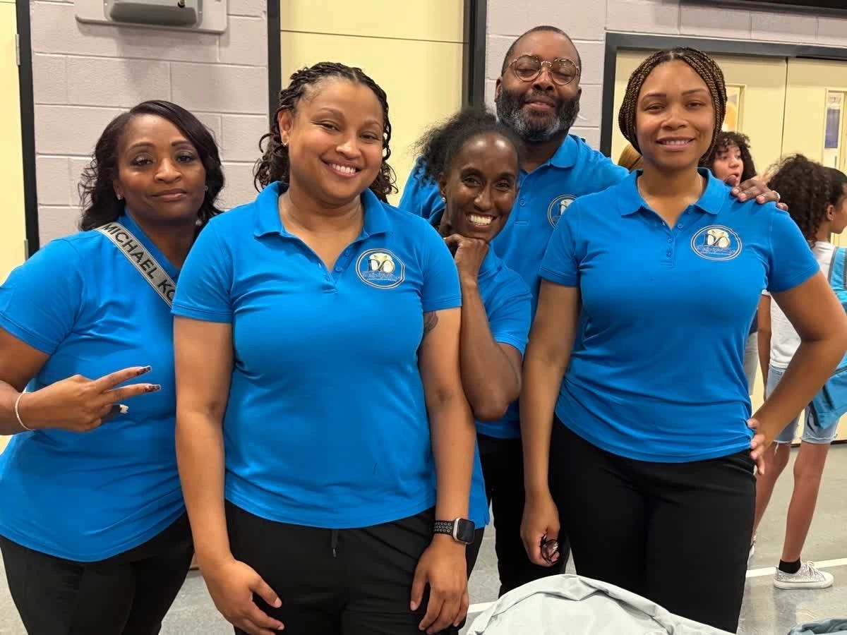 Delightful Days team members in blue uniforms smiling indoors