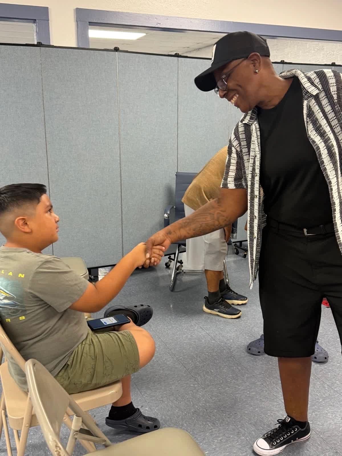 Delightful Days volunteer greeting young boy indoors