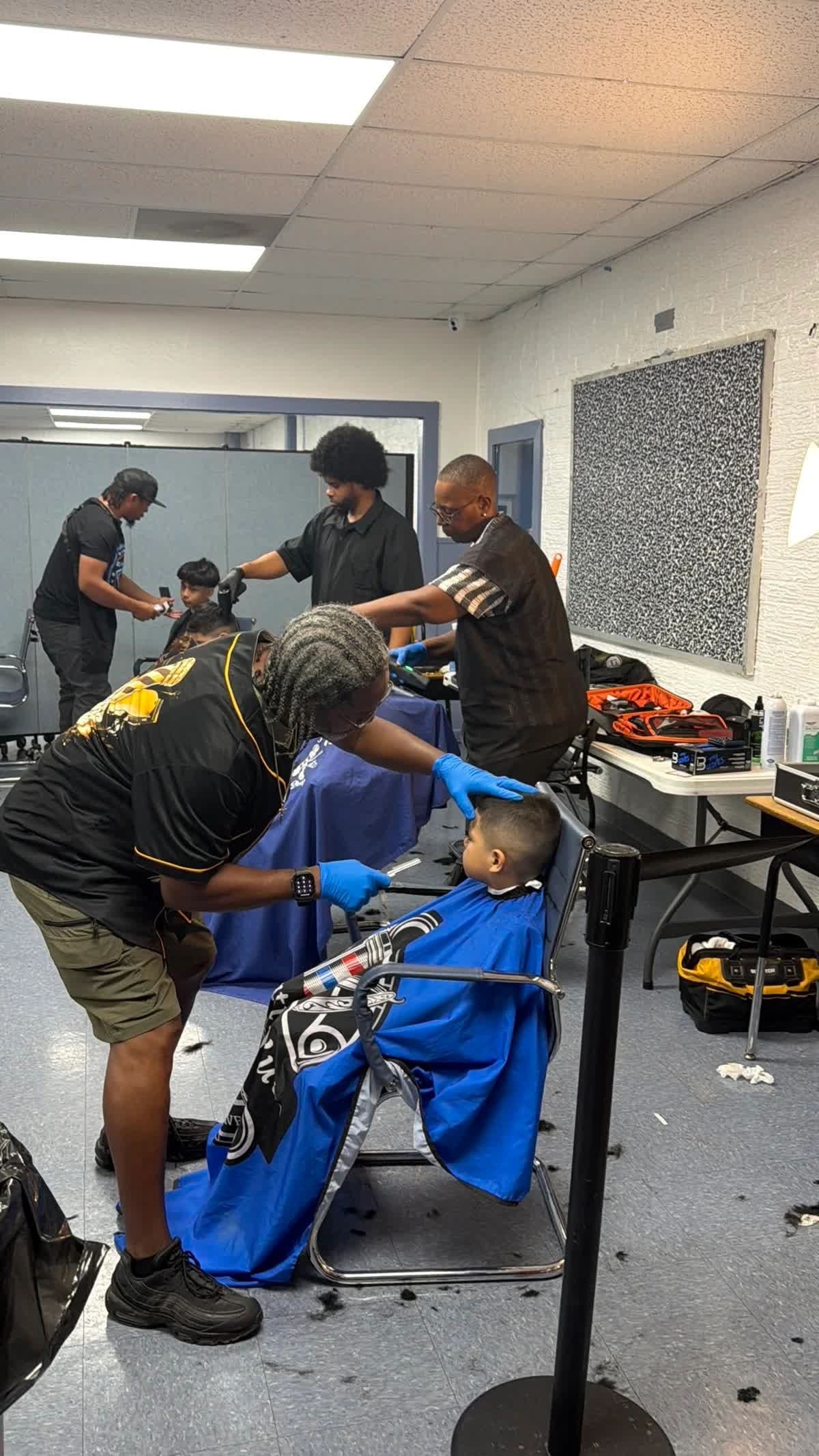 Barber professionals giving free haircuts to children at Delightful Days event